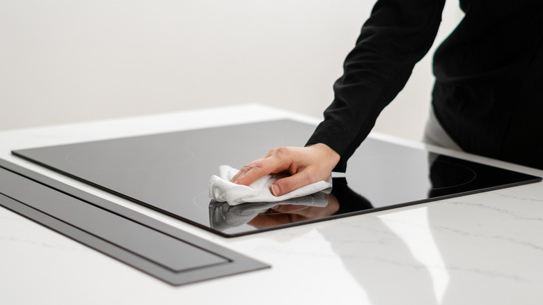 Woman wiping glass stove top