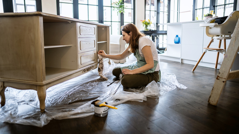 woman painting credenza