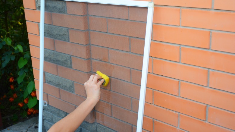 Cleaning window screens outside 