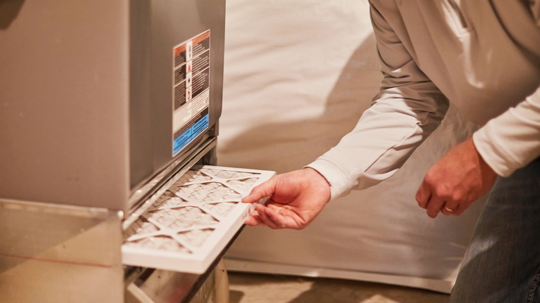 Person changing the filter in a furnace