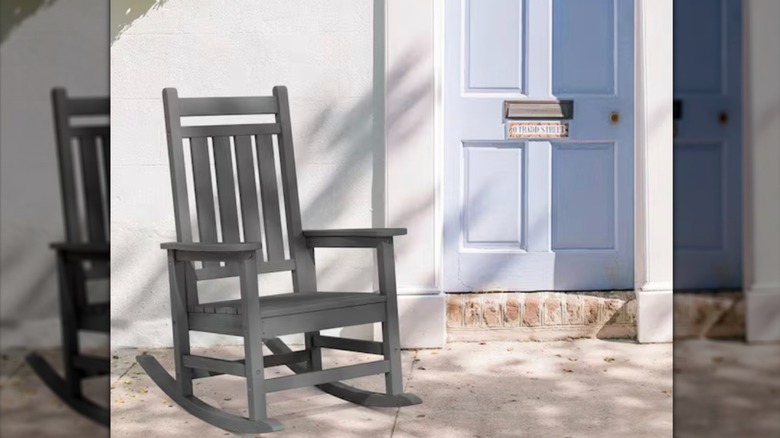 Gray Adirondack rocking chair on patio next to blue door