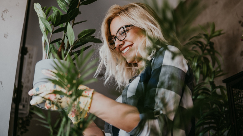 Happy woman holding houseplant