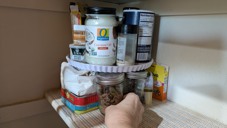 Small pantry items are better organized on a cake stand sitting on a shelf.