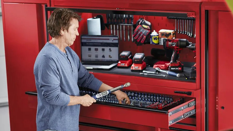 A man with a U.S. General rolling tool cabinet