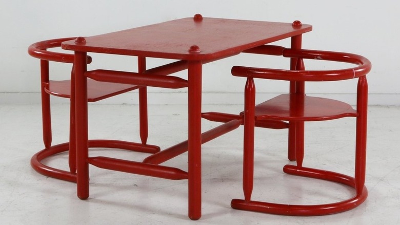 A red mid-century children's table and chairs.