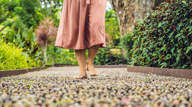 Woman walking on gravel garden