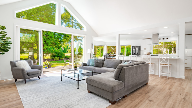 A spacious open plan living area and kitchen with huge windows looking out onto a sunny garden.
