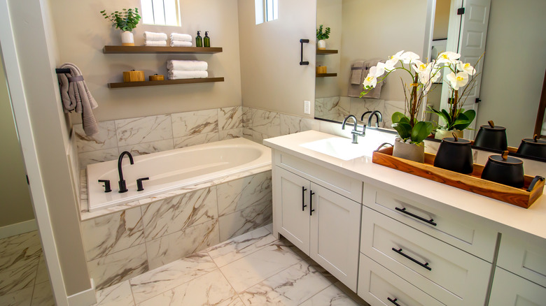 A marble en-suite bathroom with small bathtub and sink.