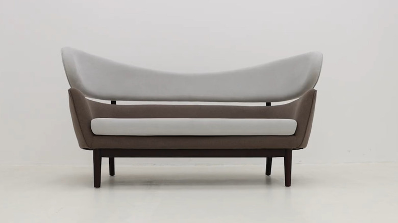 A mid-century modern Baker Sofa on a white background