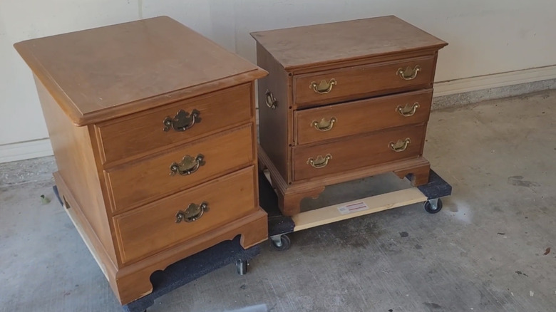 A pair of Ethan Allen side tables sitting on moving dolly outdoors.