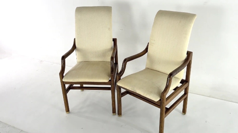 A pair of Henredon chairs with wood and cream upholstery sitting on a white background.
