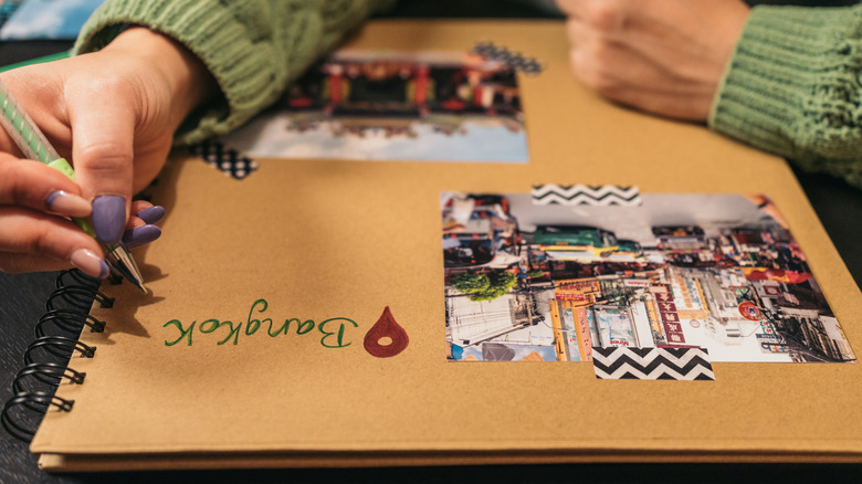 A person's hand writing in a travel journal.