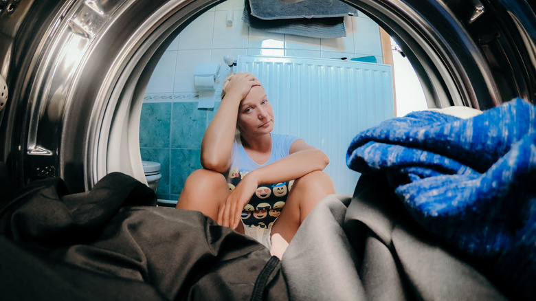 person looking at broken washer 
