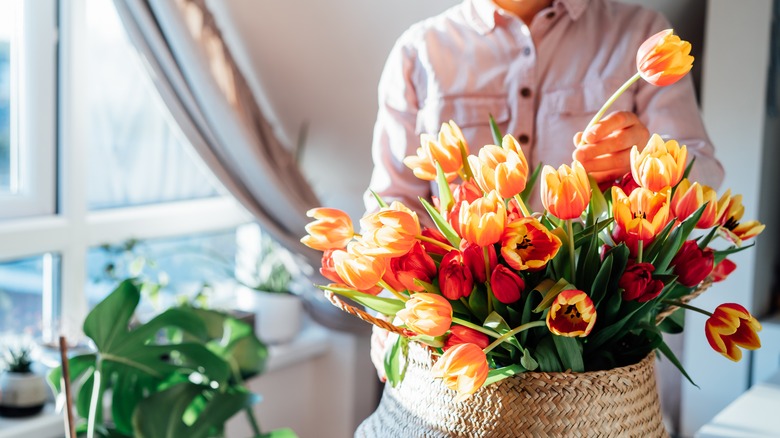 arranging tall flowers in basket