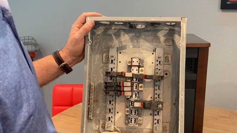 Man holding an old Federal Pacific electrical panel