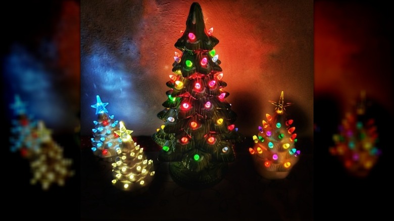 Four ceramic Christmas trees lit up