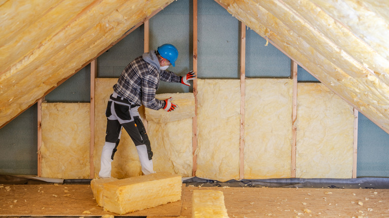 Contractor putting insulation in attic