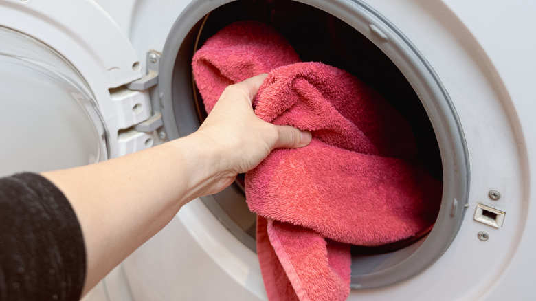 Woman placing towels in the washer