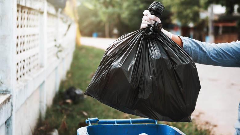 person putting trash outside