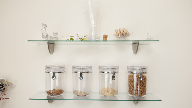 Floating glass shelves hold various décor pieces