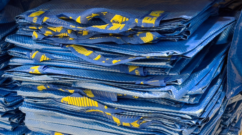 A tidy stack of flattened blue IKEA shopping bags sits neatly on a shelf