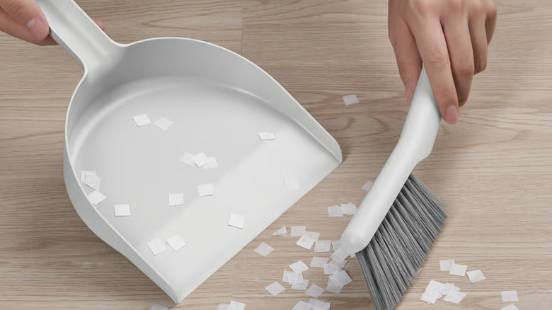IKEA hand dust pan and brush wiping up bits of paper