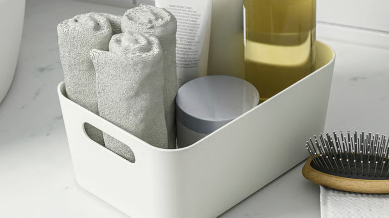 IKEA white organizing bin, filled with towels and bottles of products