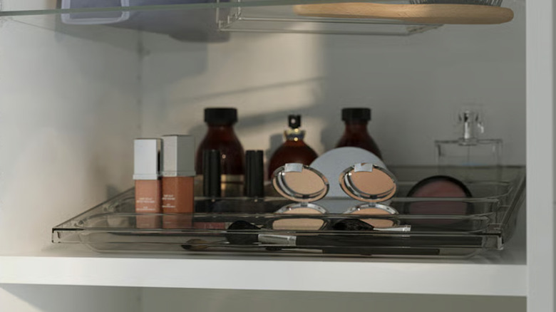 IKEA tray organizer in bathroom cabinet holding makeup and other essentials