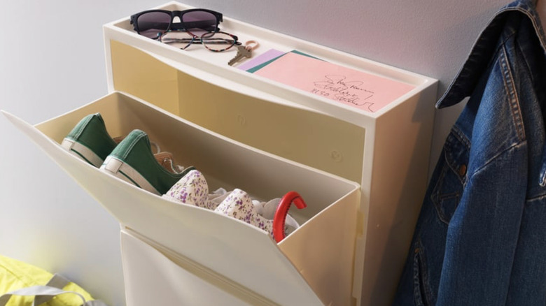 IKEA TRONES holding pairs of shoes with random accessories on top