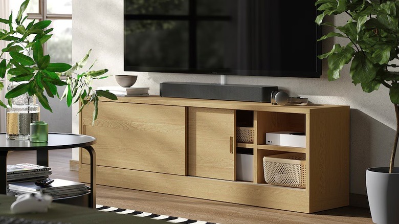 Light wood TV console with sliding doors