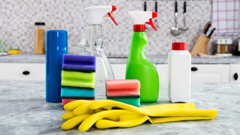 sponges, gloves, and cleaning supplies on a kitchen counter
