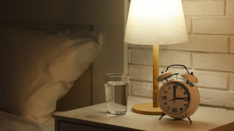 Minimalist bedside table with lamp and glass of water