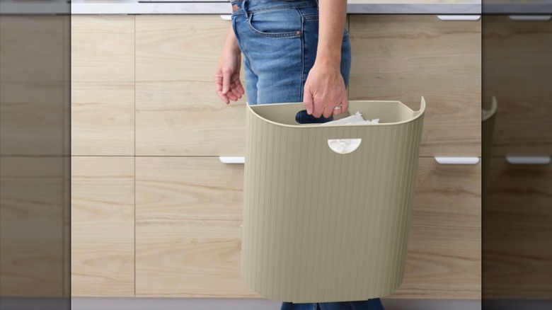 Woman carrying an IKEA GÅRDSBUTIK bin