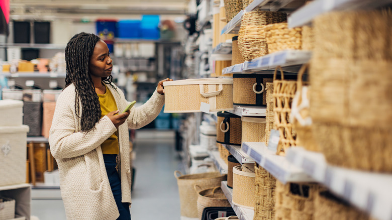 A person examines storage baskets in a store