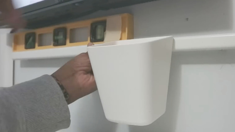 Woman using a level to mark wall for installation of IKEA SUNNERSTA