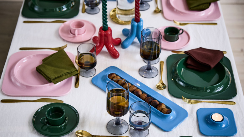 Dining table set with IKEA's new collection of dishes and candleholders