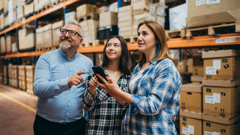 People standing in the IKEA warehouse looking up at a product on a shelf