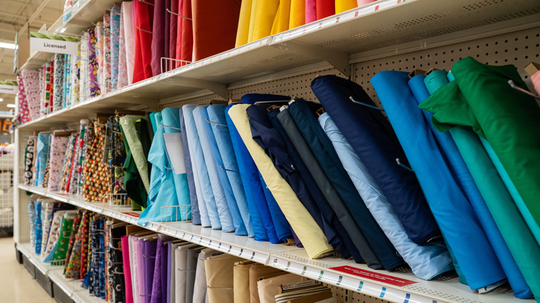 Colorful bolts of fabric on store shelves