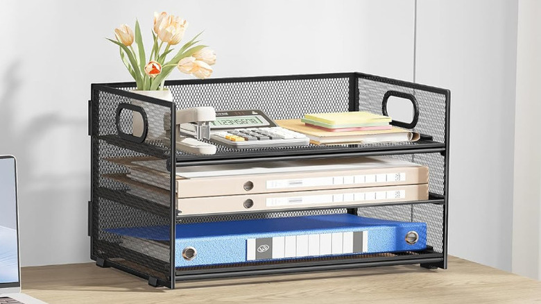 A letter organizer filled with office supplies on a desk