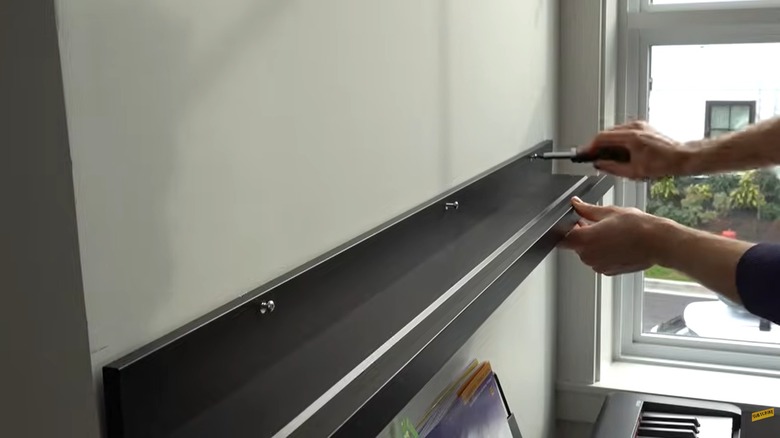 Person installing an IKEA MOSSLANDA picture ledge