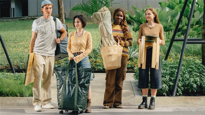 Man and women carrying items from IKEA's KOMPISHÄNG collection in a city scene,