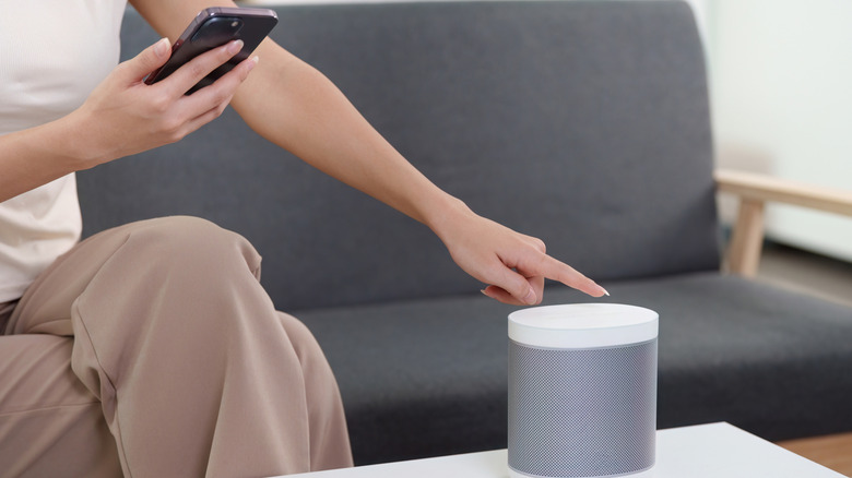 Woman pairing a smart speaker with her smartphone
