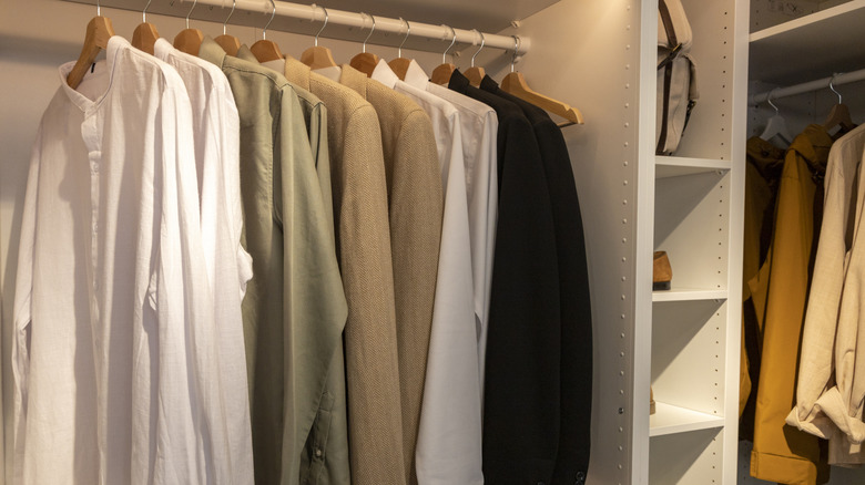 closet full of shirts on wooden hangers