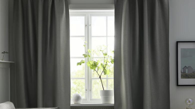 VILBORG room darkening curtains from IKEA in gray covering a window in a beige living room