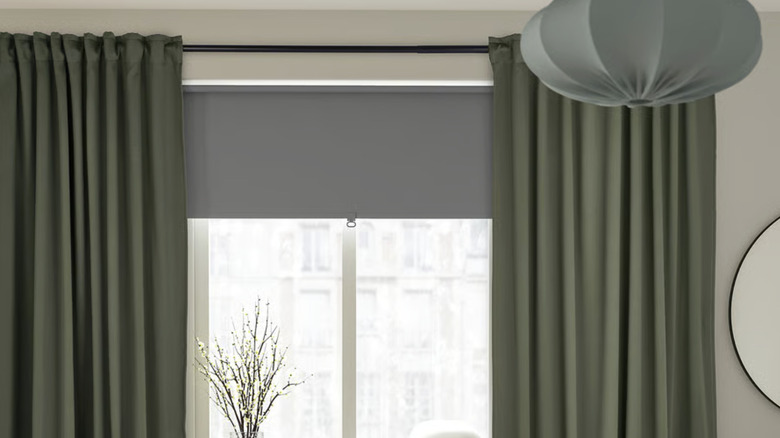 IKEA's MAJGULL curtains in dark green hanging in a beige bedroom