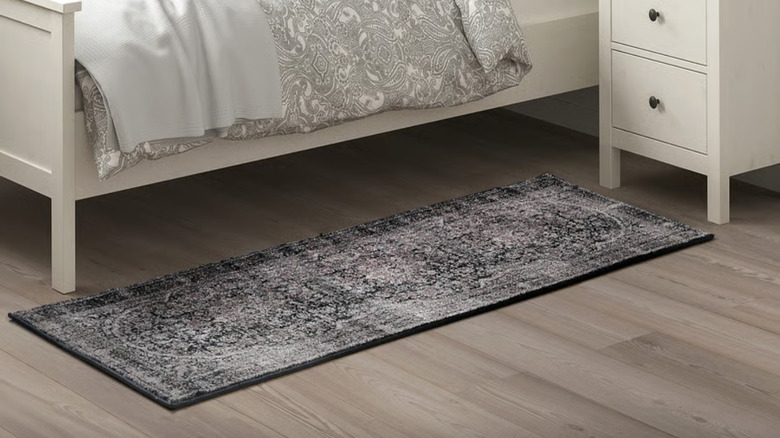 IKEA's TEBSTRUP runner in a traditional motif next to a bed and nightstand on the floor