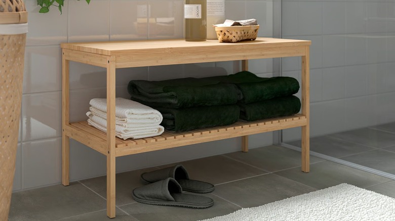 bathroom bench with towels on shelf