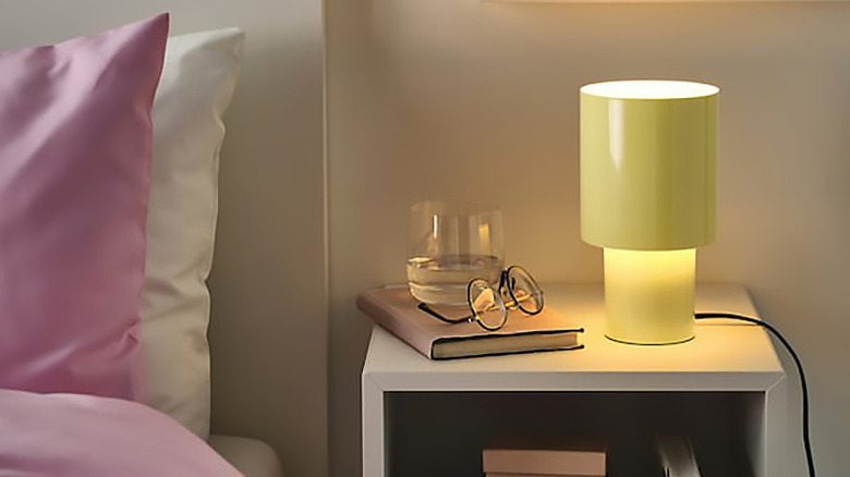 Cylindrical lamp illuminated on a night stand