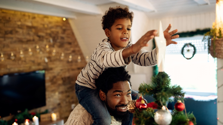 A father and son decorating their Christmas tree.