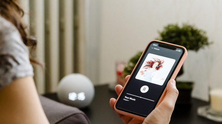 A woman listening to music on her speaker.